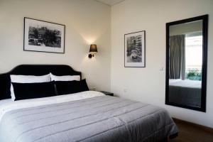 um quarto com uma cama grande e um espelho em Athens Edition Guesthouse em Atenas