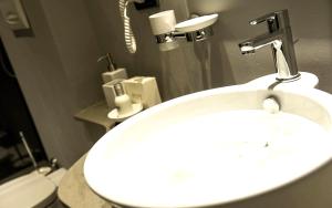 ein Badezimmer mit einem weißen Waschbecken und einem WC in der Unterkunft Hotel Chivasso in Chivasso