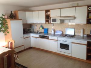 a kitchen with white cabinets and a stove top oven at Ferienwohnung Zapfl Maria in Greisdorf