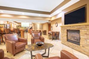 a living room with a fireplace and a tv at AmericInn by Wyndham Madison West in Madison