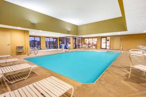 a large swimming pool with chairs at AmericInn by Wyndham Madison West in Madison