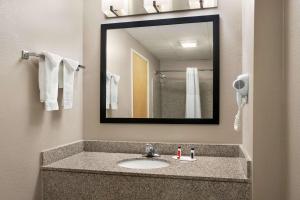 a bathroom with a sink and a mirror at Days Inn & Suites by Wyndham Murfreesboro in Murfreesboro