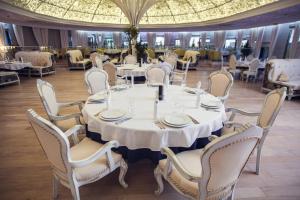 comedor grande con mesas y sillas blancas en Vetryakov Boutique Hotel, en Voronezh