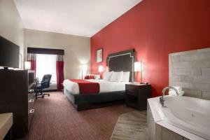 a hotel room with a bed and a bath tub at Days Inn & Suites by Wyndham Murfreesboro in Murfreesboro