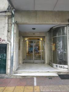 - un bâtiment avec une porte en verre et des graffitis dans l'établissement TONI'S Lovely Retreat Studio for couples in Centre, à Athènes