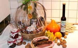 uma mesa com um cesto de comida e uma garrafa de vinho em Hotel Greif em Sankt Kanzian