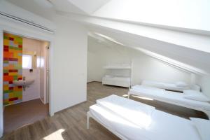 a bedroom with a white bed and white walls at Safestay Prague Charles Bridge in Prague