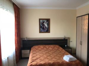 1 dormitorio con 1 cama y una foto en la pared en Art Room Sochi, en Adler
