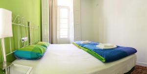 a bedroom with a blue and white bedspread and blue pillows at Leon Hostel in León