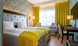 a hotel room with a bed with a yellow blanket on it at Thon Hotel Opera in Oslo