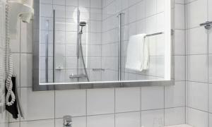 a bathroom with a shower and a mirror at Thon Hotel Opera in Oslo