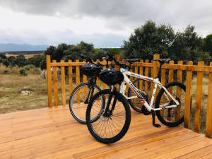 2 bicicletas están estacionadas en una terraza de madera en Domo en Montes de Toledo en Mazarambroz