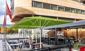 a green umbrella sitting in front of a building at Thon Hotel Opera in Oslo