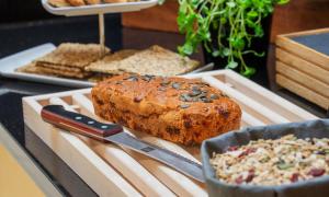 a cutting board with a loaf of bread and a knife at Thon Hotel Opera in Oslo