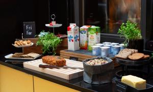 a counter with different types of bread and other foods at Thon Hotel Opera in Oslo