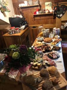 una mesa con muchos tipos diferentes de comida en ella en Affittacamere Petit Coeur, en Champoluc