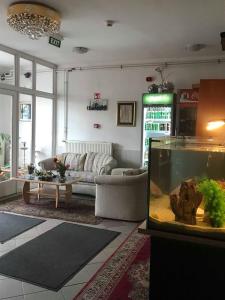 een woonkamer met een bank en een aquarium bij Népliget Hotel in Boedapest