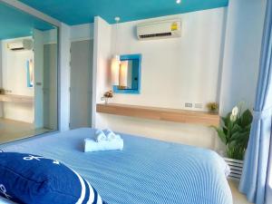 ein Schlafzimmer mit einem blauen Bett mit zwei Handtüchern darauf in der Unterkunft Atlantis Condo Resort Pattaya - Heaven for Family & Kids with Big Water Park in Jomtien Beach + 33 Fotos