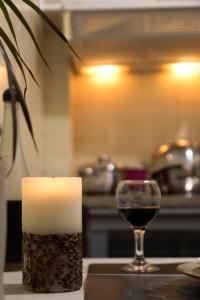 a candle and a glass of wine on a counter at Your home @Acropolis Museum in Athens