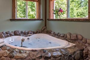 a bath tub in a room with two windows at Carson Ridge Luxury Cabins in Carson