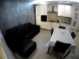 uma sala de estar com uma mesa e um sofá preto em Welcome Home!!! em Pozzallo