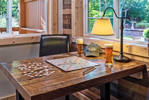 a wooden table with a lamp and two glasses of beer at Carson Ridge Luxury Cabins in Carson