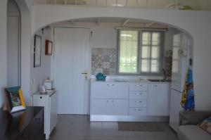 マスパロマスにあるBungalow Maspalomas, Sonnelandの白いキャビネットと窓付きのキッチン