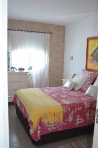 マスパロマスにあるBungalow Maspalomas, Sonnelandのベッドルーム1室(赤と黄色の毛布付きのベッド1台付)
