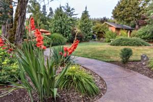 un jardín con flores rojas y una acera en Carson Ridge Luxury Cabins en Carson