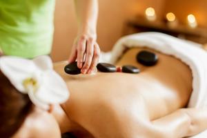 a woman laying on a bed with spa stones on her back at Carson Ridge Luxury Cabins in Carson +36 photos