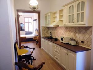 una cucina con armadi bianchi e lavandino e una camera di Zur Krone a Sibiu