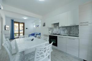 cocina blanca con mesa y armarios blancos en Casa Francesco, en San Vito lo Capo