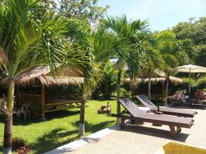 a resort with palm trees and a couple of benches at Lanta Sunny House in Ko Lanta