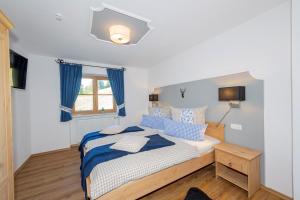 ein Schlafzimmer mit einem Bett mit blauen und weißen Kissen in der Unterkunft Ferienwohnung Hirscheck in Schönau am Königssee
