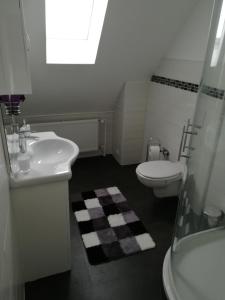 a white bathroom with a sink and a toilet at Ferienwohnung am Weinberg in Bad Ems