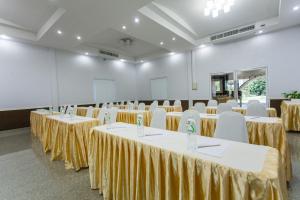 Cette chambre comprend des rangées de tables et de chaises blanches. dans l'établissement Boom Forest Hotel, à Hat Yai