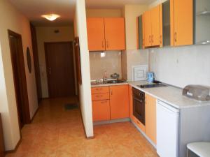 una pequeña cocina con armarios naranjas y fregadero en Apartment in Elit 3 Apartcomplex, en Sunny Beach