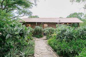 un jardin avec un chemin en pierre menant à une maison dans l'établissement Belvedere Game Ranch, à Magudu