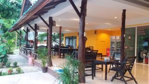 a restaurant with tables and chairs and plants at Lanta Sunny House in Ko Lanta