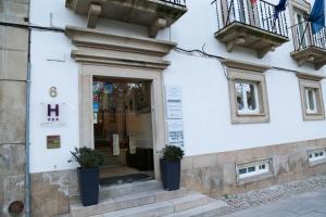 un edificio bianco con due piante in vaso sulla porta di INATEL Castelo De Vide a Castelo de Vide