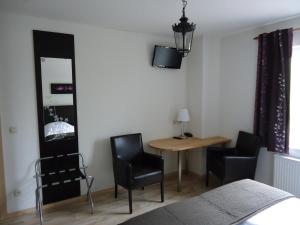 a bedroom with a table and two chairs and a bed at Hostellerie des Tilleuls in Smuid