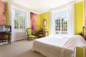 ein Schlafzimmer mit einem Bett und einem Fernseher und Fenstern in der Unterkunft Hotel Les Goelands in Saint-Jean-de-Luz