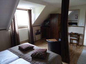 een slaapkamer met een bed met 2 kussens en een raam bij Hostellerie des Tilleuls in Smuid