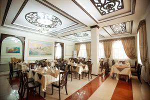 a restaurant with tables and chairs and a ceiling at Hotel Asia Khiva in Khiva