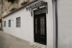 a black door on the side of a white building at Family Hotel Triston in Tbilisi City