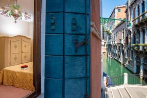 a blue door with a view of a canal at Hotel Mercurio in Venice