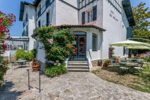 um edifício com um pátio com mesas e cadeiras em Hotel Les Goelands em Saint-Jean-de-Luz