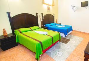 1 dormitorio con 2 camas y TV. en Hotel Santa Maria, en Panajachel