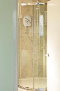 a shower with a glass door in a bathroom at Leeward House B&B in Gosport