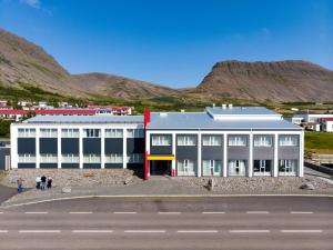 un grande edificio bianco con montagne sullo sfondo di Fosshotel Westfjords a Patreksfjörður